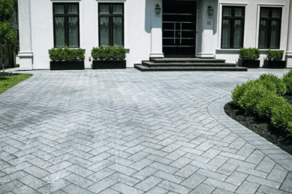 Herringbone patio stone driveway with natural stone steps and boxwood bush border in Elora, ON