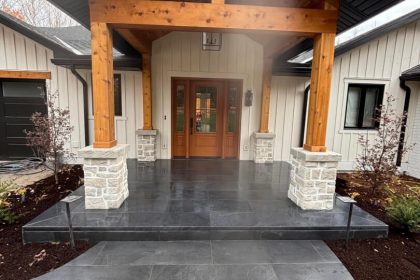 Beautiful front entrance curb appeal with large format black porcelain overlay over poured concrete, cedar post accents, and door in Cambridge, Ontario.